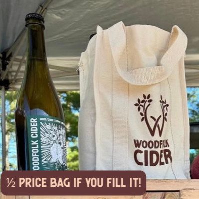 Woodfolk Cider bottle and reusable bag with promotional text outdoors